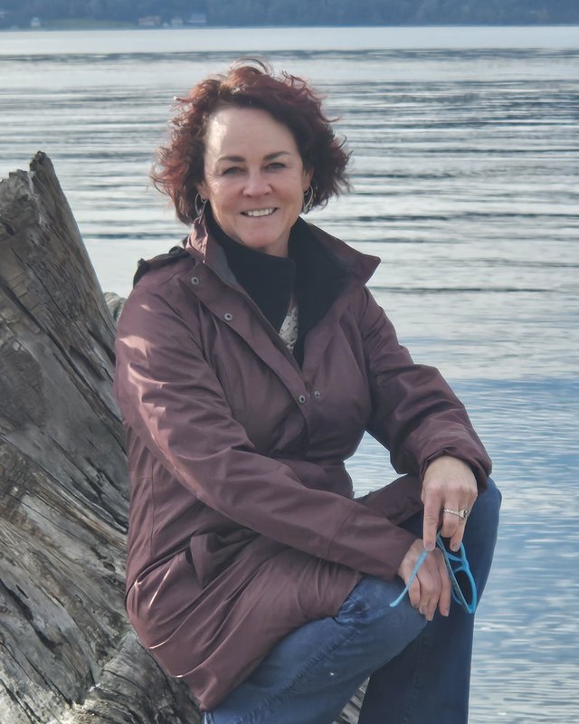 Kathy Miller, owner and publisher of Kids&rsquo; Directory Charlotte, smiling by the water in Seattle