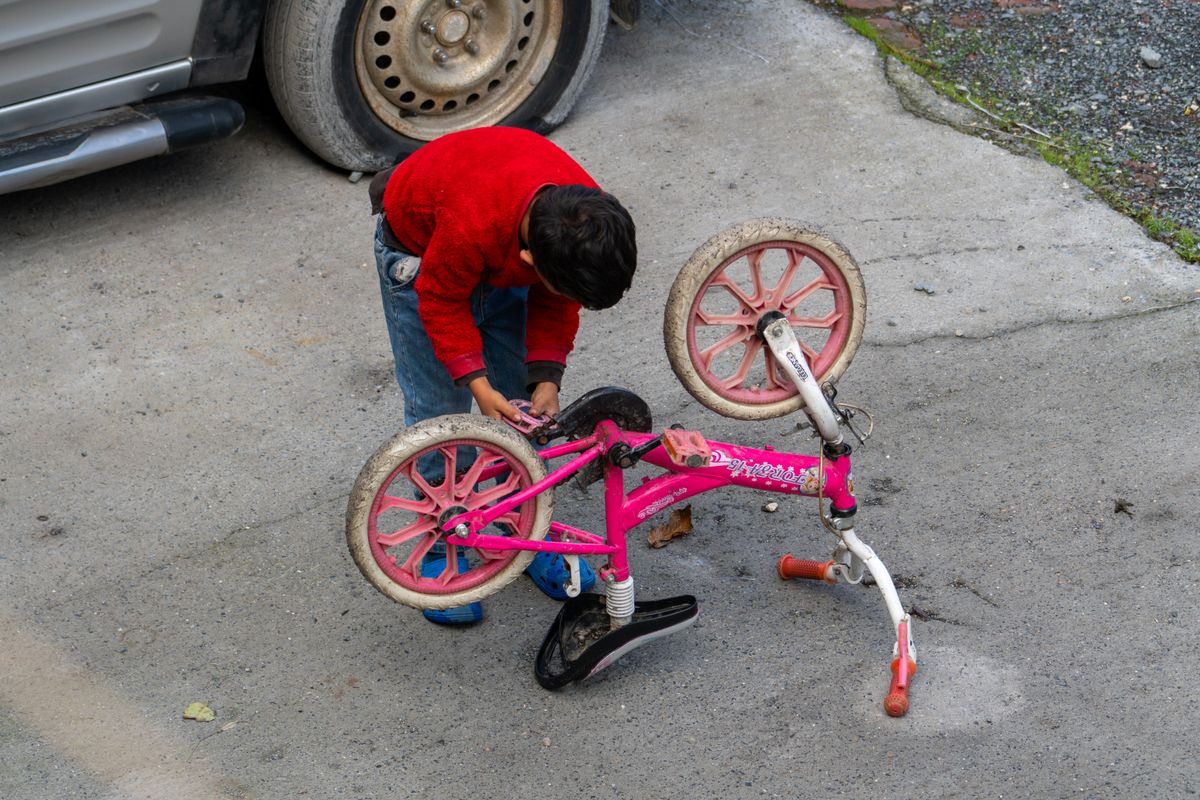 Child checking a pink bike before a ride