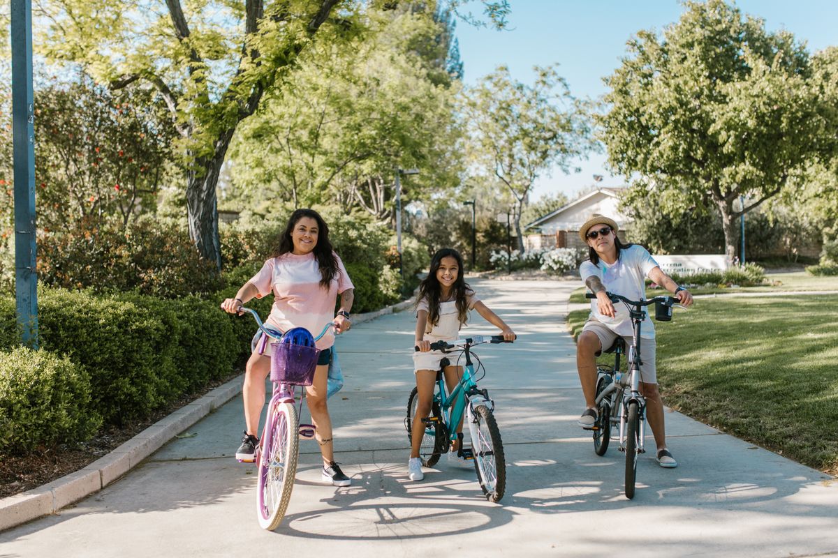 Family riding bikes together on a paved park path
