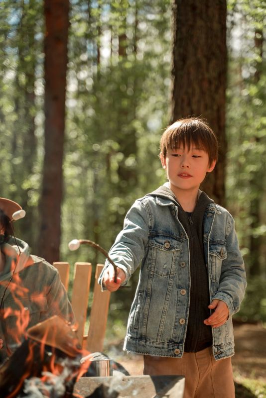A boy roasting a marshmallow over a campfire