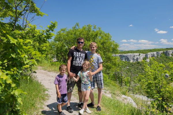 Dad and three kids on a sunny hiking trail