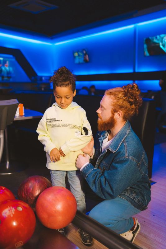 Dad teaching his son to bowl