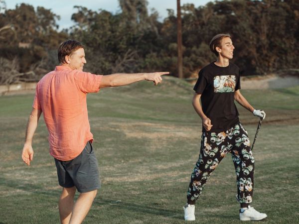 Dad and son out on the green with golf clubs