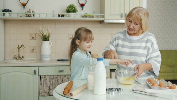 Grandma and granddaughter baking together in the kitchen