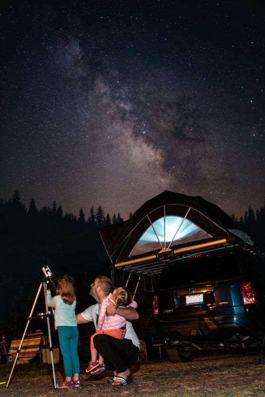 A glowing tent under a starry night sky